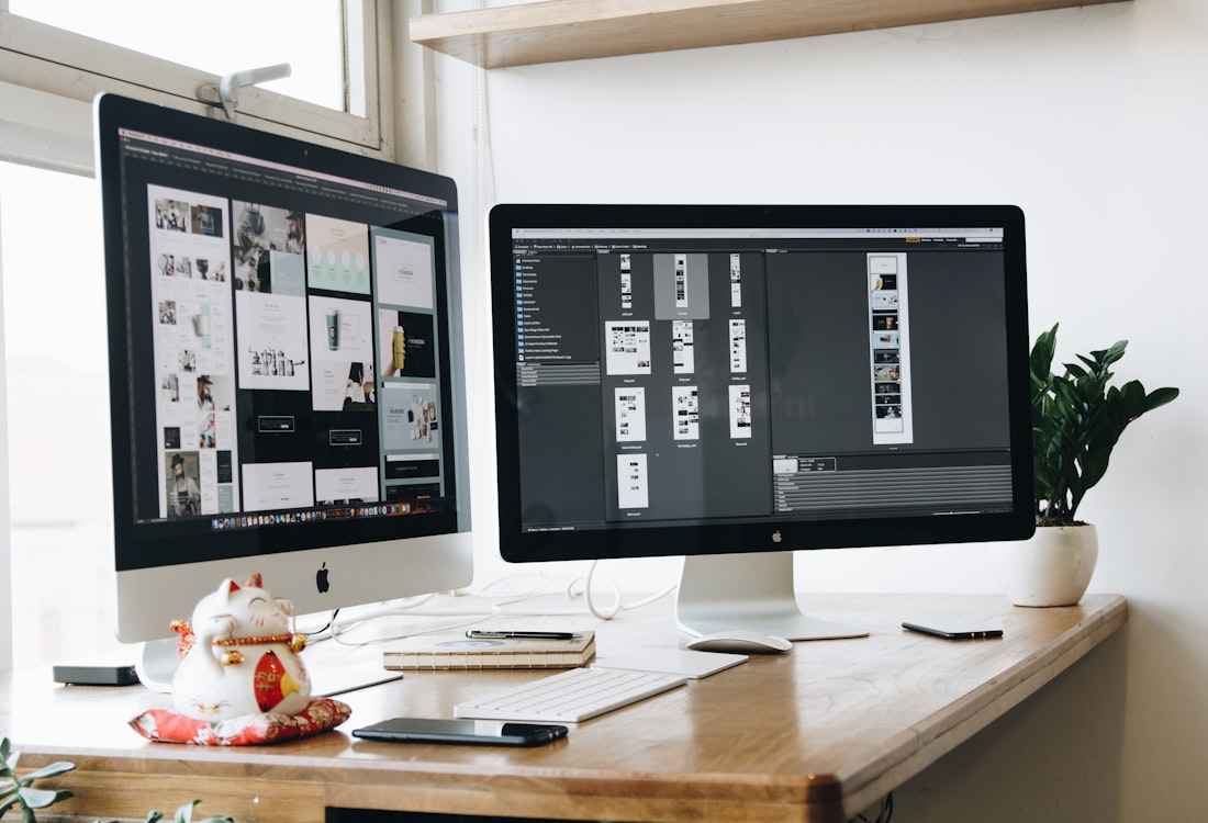 Web designer working at a desk with dual monitors